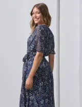 Vestido largo con estampado floral multicolor, escote en V cruzado, cintura elastizada con lazo de ajuste y forro interno. Marca Sandra Darren.