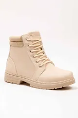 Bota tipo borcego color beige con cordones tono sobre tono y cuello tejido acanalado en el tobillo.