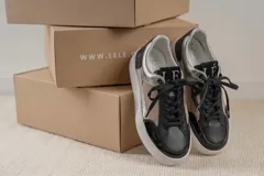 Zapatillas urbanas de cuero sintético negro con detalles en plateado y beige.