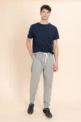 Pantalon deportivo tipo jogger en color gris melange, con cintura elastizada y cordón de ajuste frontal.