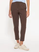 Babucha color marrón confeccionada en bisou, con cintura elastizada y detalle de jareta con lazo de cinta valenciana a tono. Cuenta con bolsillos laterales en el delantero y un ajuste cómodo.