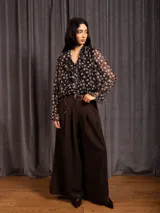 Pantalon tipo palazzo de corte amplio y tiro alto, con pinzas frontales, bolsillos laterales y cintura elástica.