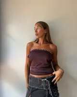 Minifalda de jean color negro con efecto desgastado, diseño de tajo frontal y cinturón integrado con hebilla metálica grande.