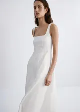 Vestido midi color blanco de lino, sin mangas, con escote cuadrado, corte en la cintura y falda evasé con bolsillos laterales.