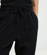Pantalón de pijama de corte holgado, confeccionado en franela de algodón. Presenta cintura elástica con cordón de ajuste y diseño de rayas verticales.
