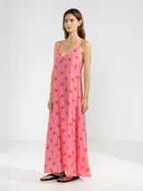 Vestido largo de corte fluido con escote en V profundo y finos breteles. Presenta un estampado animal print combinado con rayas y un detalle decorativo de flor en cobre en el centro del escote.