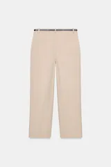 Pantalón tobillero de corte recto en color beige, con detalle de nervio delantero marcado. Incluye cinturón fino, bolsillos delanteros y cierre frontal con cremallera, botón interior y gancho.