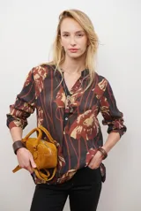 Camisa de manga larga con estampado floral en tonos marrones y negros, cuello mao y cierre frontal parcial con botones.