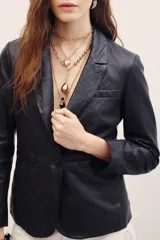 Blazer de cuero ovino color negro, con solapas clásicas, cierre frontal de un botón y bolsillos con solapa.