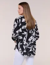 Blusa de gasa de calce suelto y caída ligera, color azul con estampado floral blanco. Presenta escote en V con cuello mao, tabla central, mangas largas regulables con presilla y botón, ruedo redondeado de estilo mullet y espalda con canesú y pliegue central.