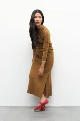 Falda larga marrón de punto con elástico en la cintura y botones decorativos en un lateral.