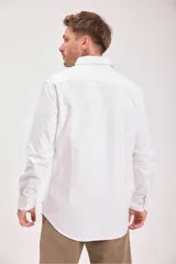 Camisa blanca de manga larga con cuello clásico y cierre frontal con botones.