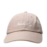 Gorra tipo baseball color beige con bordado frontal en hilo blanco que dice Nashville.