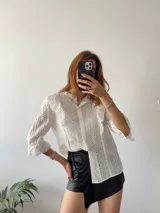 Short pollera negro de cuero sintético con detalle cruzado y lazo lateral.