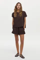 Blusa de lino color blanco, con cuello bote y mangas cortas de corte holgado.