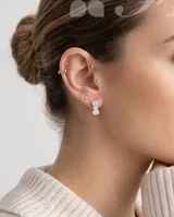 Caravanas de plata con diseño de moña, adornadas con circonias brillantes. Cuentan con cierre catalán.