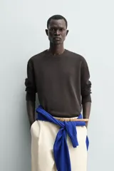 Jersey de punto de corte regular, confeccionado en una mezcla de algodón y lino. Presenta cuello redondo, manga larga y acabados en rib en cuello, puños y bajo.