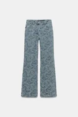 Pantalón jean tiro alto de corte flare con diseño jacquard estampado completo, cinco bolsillos, trabillas para cinto y cierre frontal con cremallera y botón metálico.