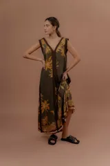 Vestido largo verde militar con estampa tropical de palmeras en tonos amarillos, escote en V y detalles en marrón.