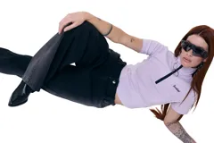 Top corto lila de gabardina elastizada, con cuello alto, cierre frontal, mangas cortas y logo Temblad bordado en el pecho.