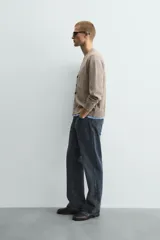 Cárdigan de punto con cuello en pico y manga larga. Presenta un diseño de ajuste relajado con cierre frontal de botones y acabados en rib con efecto doble en color azul a contraste sobre la base color topo.