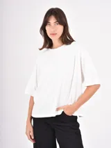 Remera blanca de corte oversize, con cuello redondo y mangas cortas de caída amplia.