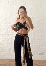 Top corto con estampado animal print en tonos verde y negro, con detalles de encaje negro en el escote y ruedo.