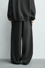 Pantalón de corte baggy fit confeccionado en tejido técnico, con cintura elástica ajustable mediante cordón y bajo con elásticos laterales para ajuste.