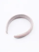 Vincha rígida color rosa claro con textura tejida.