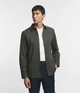 Camisa de manga larga confeccionada en tricolina de algodón, con cuello inglés, cierre frontal de botones y puños abotonados. Diseño liso y versátil.