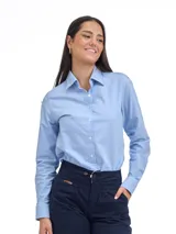 Camisa de corte clásico en tejido Oxford color celeste, con cuello camisero, cierre frontal de botones y mangas largas con puños abotonados. Presenta un pequeño logo bordado en el pecho.