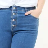 Pantalón de jean estilo skinny, de tiro muy alto con cierre frontal de botones expuestos. Presenta un lavado azul clásico y ajuste ceñido en las piernas.
