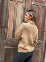 Sweater camel de punto trenzado con cuello alto.