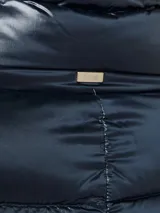 Campera larga de nylon color azul marino, con relleno de plumas, cuello alto y cierre con botones a presión.