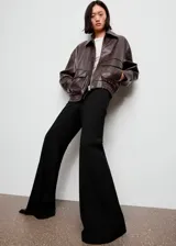 Pantalón flare de tiro alto color negro, con diseño largo y cierre de cremallera lateral.