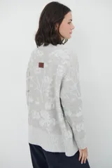 Buzo de tejido de punto con cuello redondo, mangas largas con puños acanalados y diseño estampado de flores en tonos rojos.