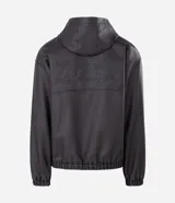 Chaqueta masculina de poliuretano color negro, con diseño de capucha, cierre frontal completo y puños elásticos. Presenta un acabado liso y estructura robusta.