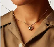 Collar dorado con dije en forma de corazón.