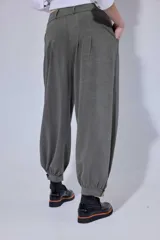 Pantalón tipo bombachita con pinzas que aportan volumen, confeccionado en Tencel. Presenta cierre frontal con botones dorados, bolsillos delanteros y ruedo ajustable mediante botón dorado.