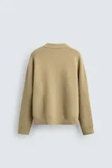 Jersey de punto con textura efecto pelo, corte relajado, cuello redondo y manga larga con acabados en rib.