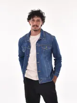 Campera de jean azul con cuello clásico, cierre frontal con botones metálicos, bolsillos con solapa abotonada en el pecho y bolsillos laterales.