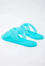 Sandalia chata de goma semi transparente color gris, con doble tira entrelazada sobre el empeine.