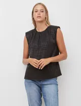 Blusa sin mangas negra con textura de cuadros en relieve, cuello redondo con frunce y hombreras.