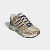 Championes Adidas Adistar Control 5 con diseño retro inspirado en los años 2000. Presenta parte superior de malla transpirable color beige con estampado animal print de leopardo, capas superpuestas de cuero peludo, las tres tiras características de la marca en azul marino y cordones oscuros.