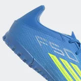 Championes de fútbol Adidas F50 Club para pasto sintético, color azul con detalles en amarillo neón. Presentan exterior Fiberskin con textura 3D, lengüeta flotante ventilada y suela de caucho con tapones pequeños para mayor tracción.