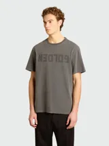Remera gris de algodón con efecto desgastado, cuello redondo y estampado con la palabra 'GOLDEN' invertida en el frente.