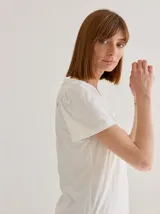 Remera de algodón con escote en V, mangas cortas con frunces en los hombros y detalle de bolsillo frontal con costuras a la vista.