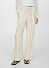 Pantalon de corte recto y diseño fluido, confeccionado en una mezcla de lyocell y viscosa. Presenta cintura elástica con cordón ajustable, bolsillos laterales y un acabado texturizado.