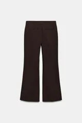 Pantalón de tiro bajo color marrón, con bolsillos frontales, falsos bolsillos traseros de vivo y cierre delantero con cremallera y gancho metálico.
