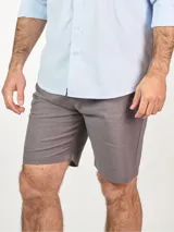 Bermuda color beige confeccionada en lino, con bolsillos laterales y traseros, y presillas para cinturón.